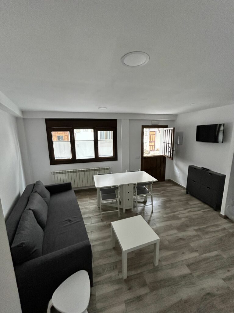 Salón comedor con TV y mesa desplegada